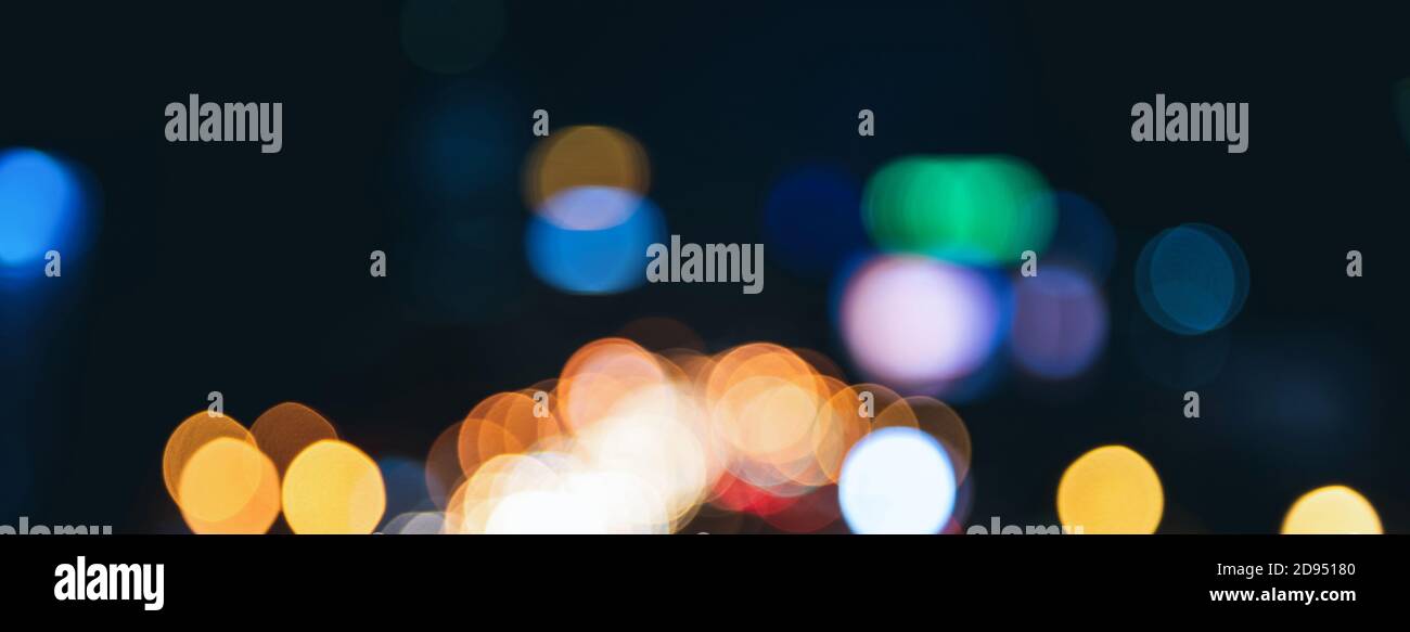 Blurred colorful bokeh light at night on dark banner background Stock Photo