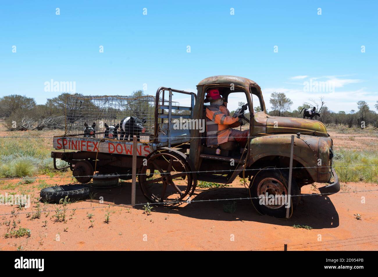 Old rusty ute on display with a mannequin and pigs statues outside Windorah, a sleepy remote Outback town, Queensland, QLD, Australia Stock Photo