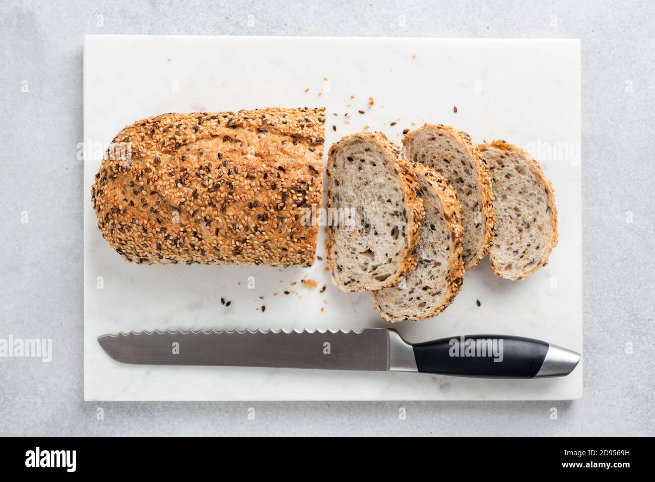 Multigrain bread sliced on marble texture. Top view of healthy bread with seeds Stock Photo