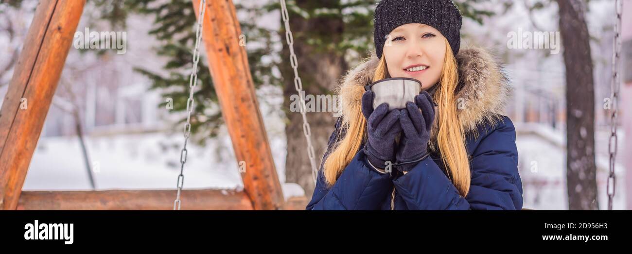Woman drinks tea from a thermos on a winter day BANNER, LONG FORMAT Stock Photo
