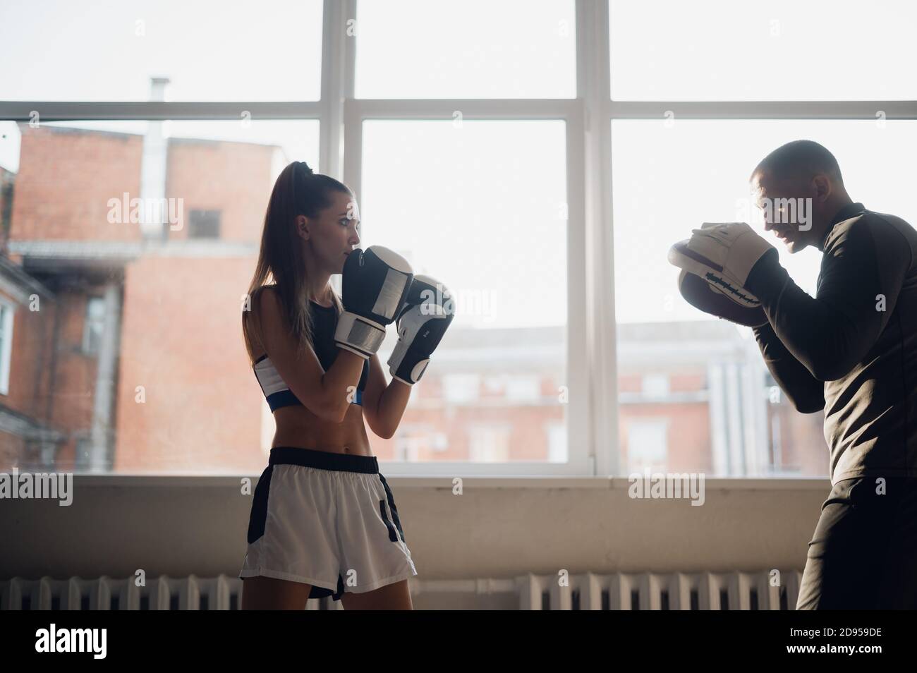 A man and a woman sparring partners train in the fighters training hall