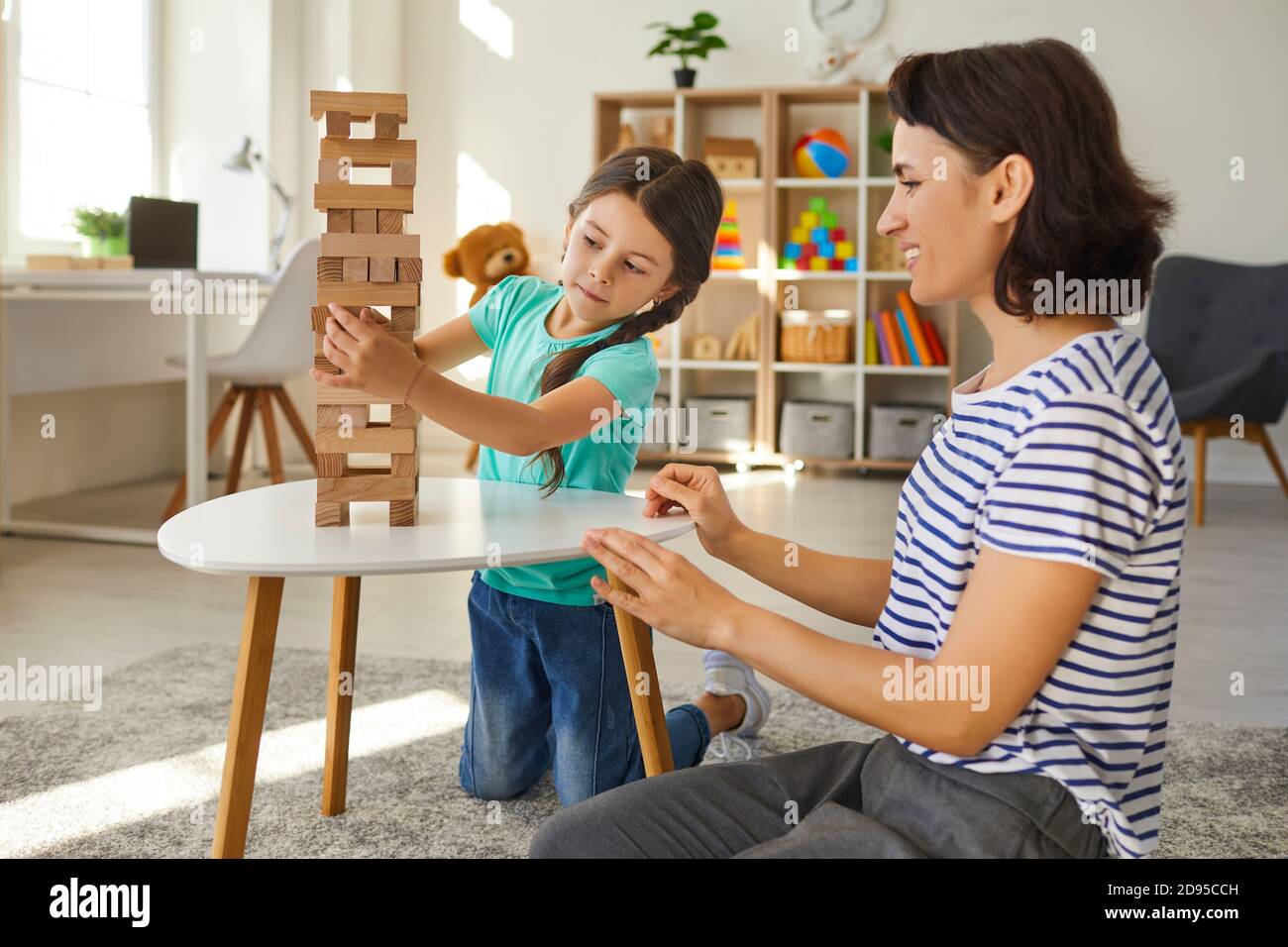 Mother and daughter play board games at home. Happy family. Stock Photo