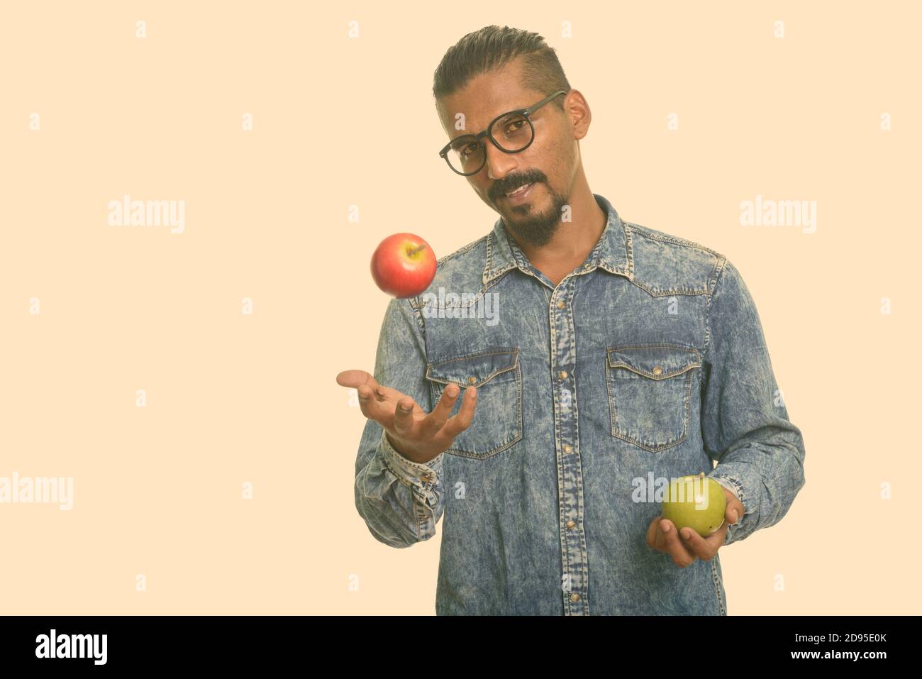 Young Indian man holding red and green apple Stock Photo - Alamy