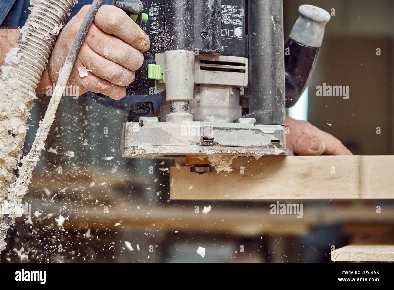 Carpenter with hand electric router machine at work. Milling process of ...