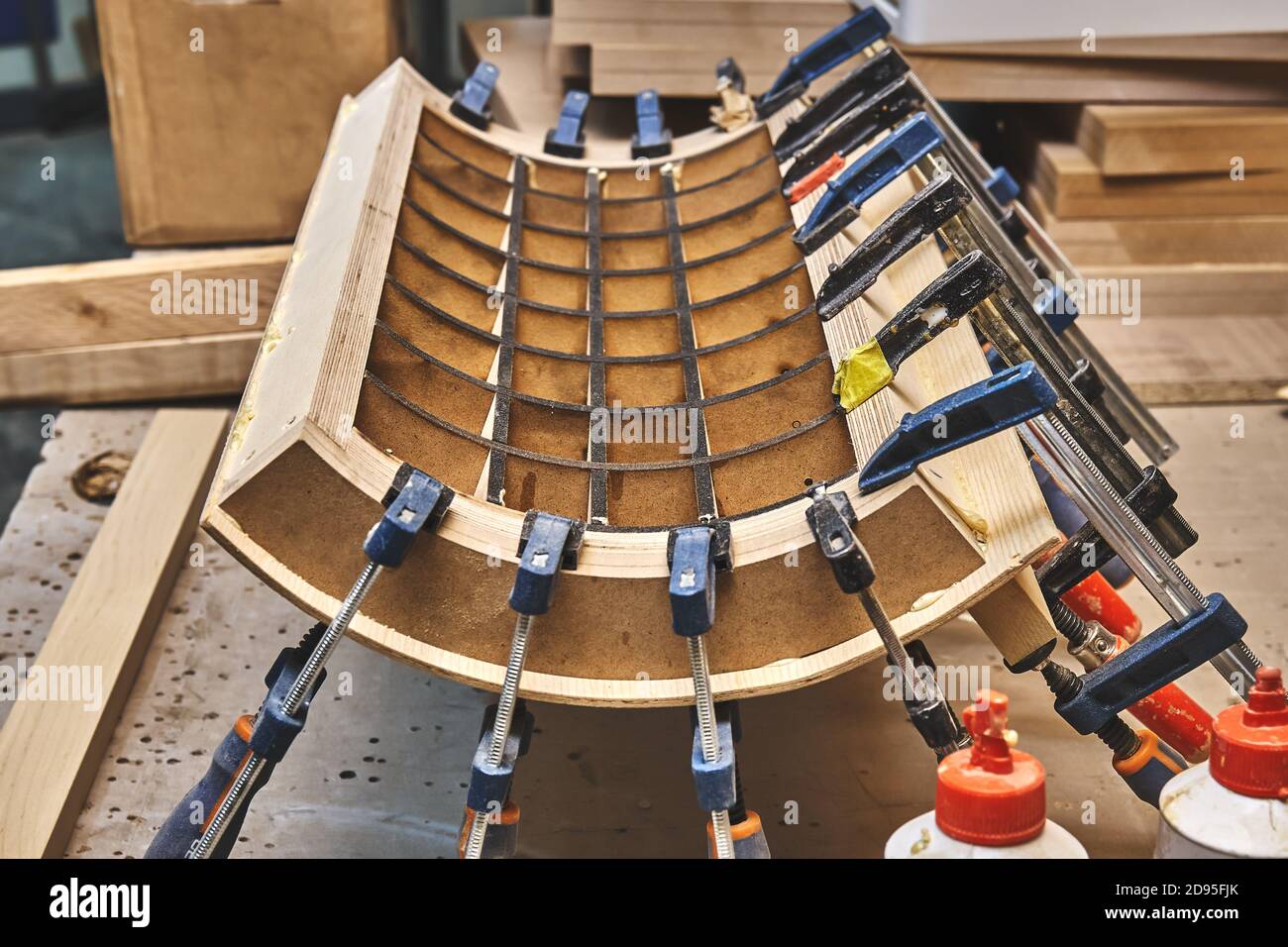 Joinery. Plywood bending process closeup. Gluing and clamping bend