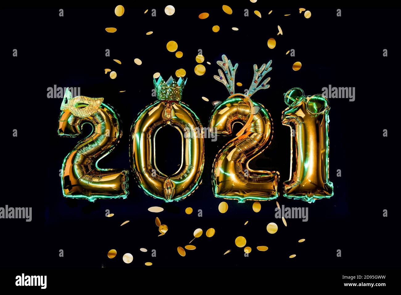 Gold numbers 2021 on black background in carnival accessories, new year party Stock Photo