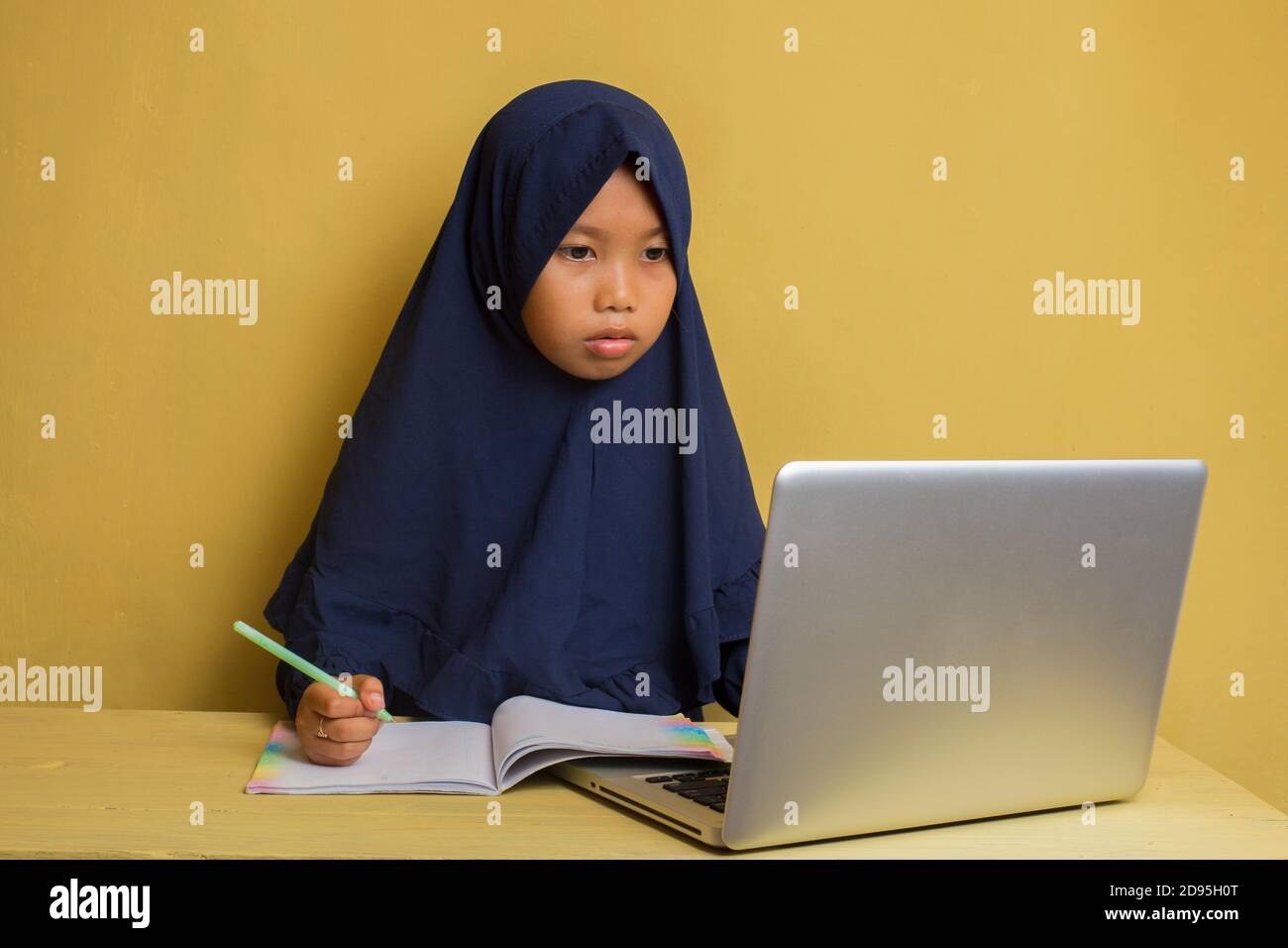 Smart Little asian muslim hijab girl using her laptop computer Stock ...