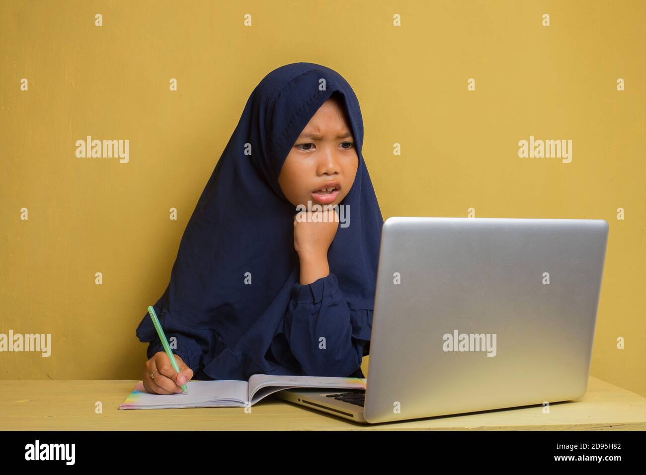 Smart Little asian muslim hijab girl using her laptop computer Stock ...