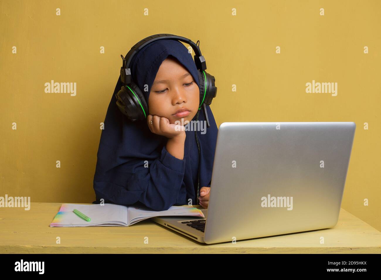 Smart Little asian muslim hijab girl using her laptop computer Stock ...