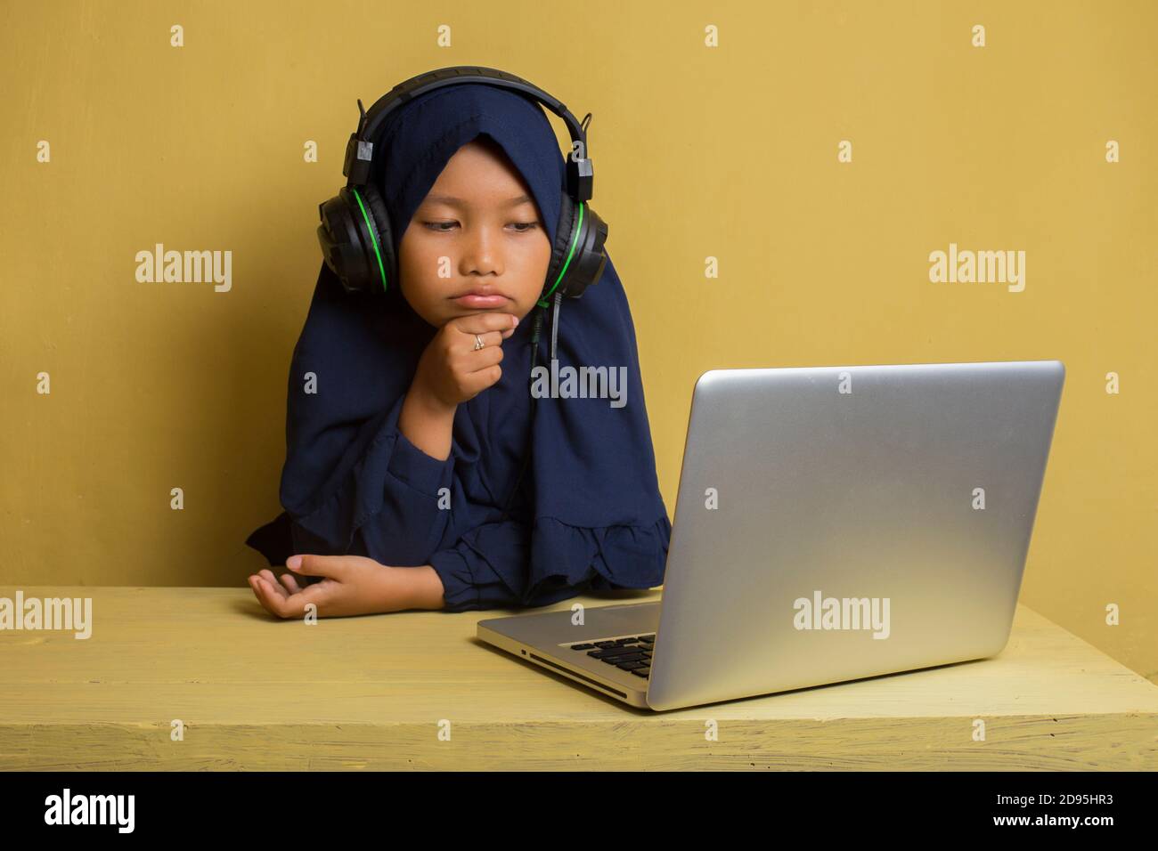 Smart Little asian muslim hijab girl using her laptop computer Stock ...