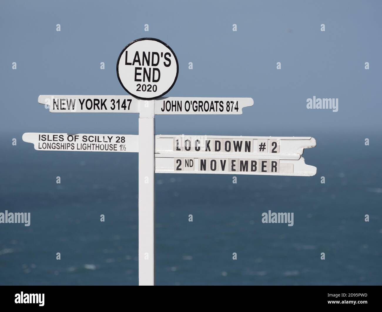 Iconic signpost at Land's End in UK has 'Lockdown#2' written on it indicating current affairs in UK Coronavirus epidemic rest Stock Photo