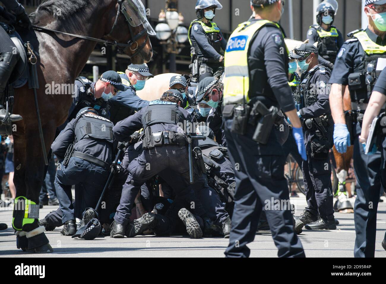 Melbourne, Australia 03 Nov 2020, a group of police wrestle with a man on the ground as they attempt to handcuff him after taking final action to end the protest and fine all the protesters at the State Parliament during another Freedom Day demonstration on Melbourne Cup Day demanding the sacking of Premier Daniel Andrews over lockdown laws. Credit: Michael Currie/Alamy Live News Stock Photo
