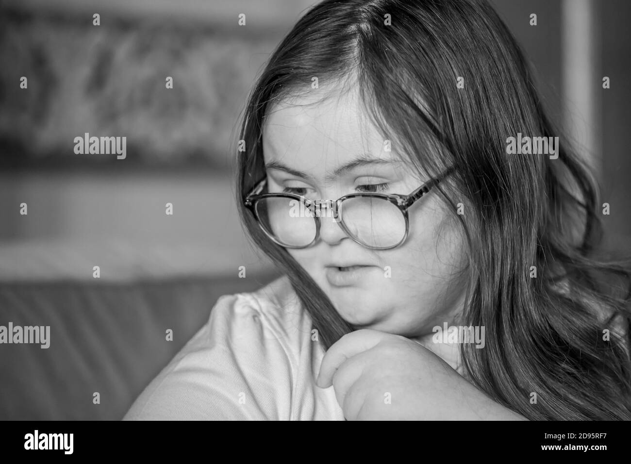 Young female teenage with Downs Syndrome brushing her hair indoors, Northampton, England, UK. Stock Photo