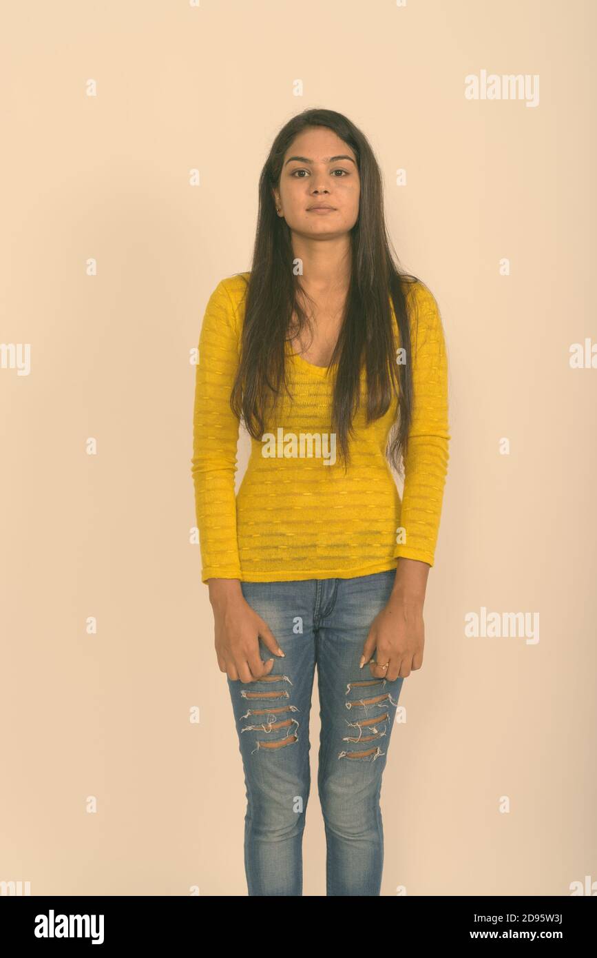 Studio shot of young Indian woman standing against white background Stock Photo
