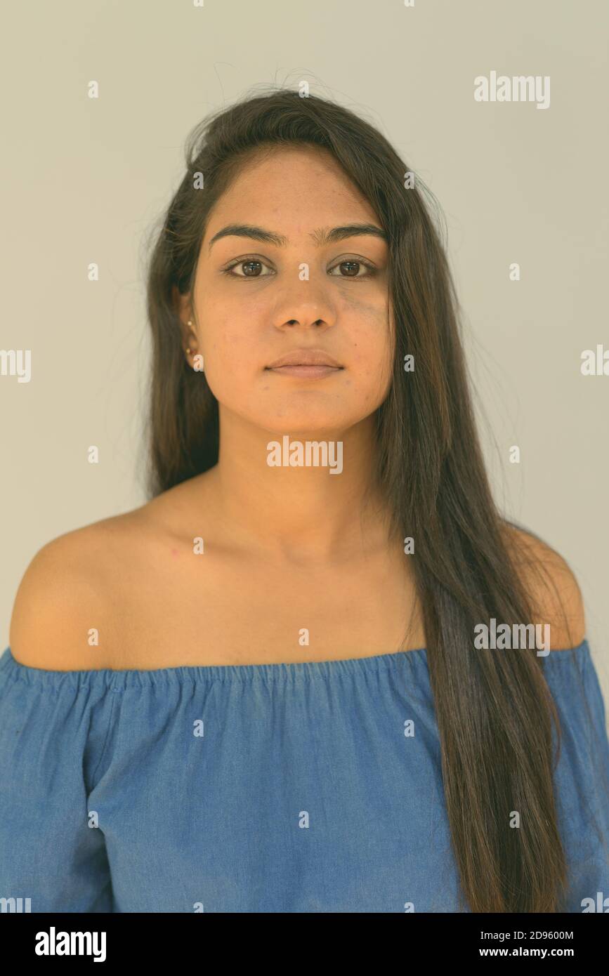 Face of young Indian woman against blue background Stock Photo