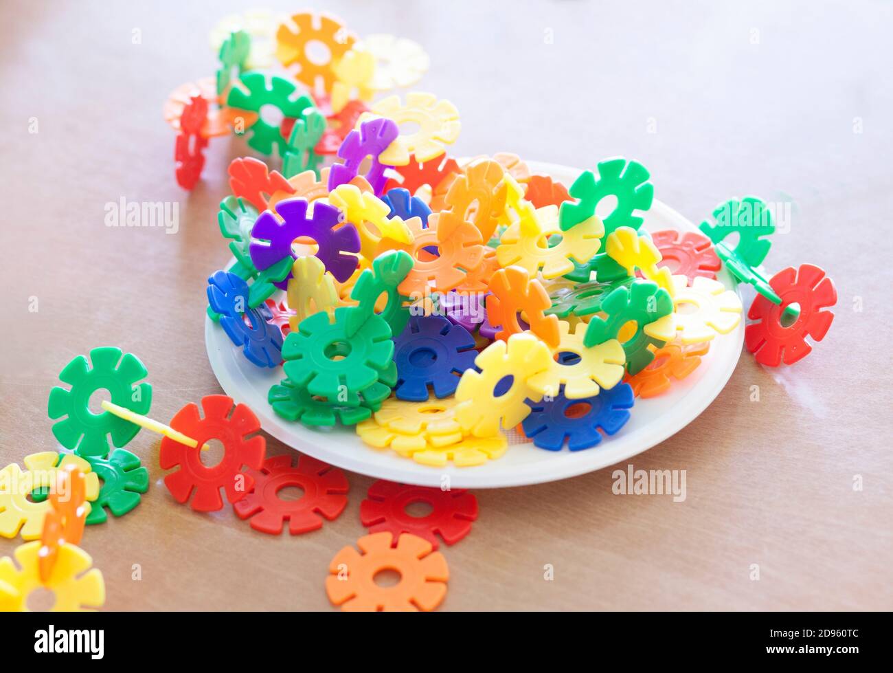 Plastic flakes blocks on plate. Instructive toy that promotes spatial hhinking and fine motor skills. Stock Photo
