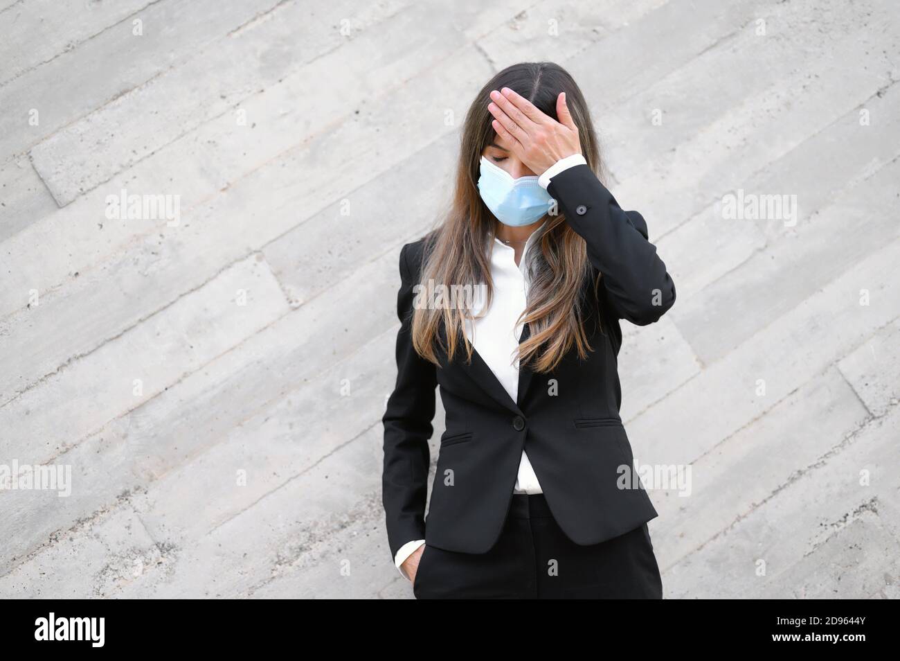 Sick young businesswoman wearing face mask,. Ill female worker having coronavirus, flu infection symptom concept. High quality photo. Stock Photo