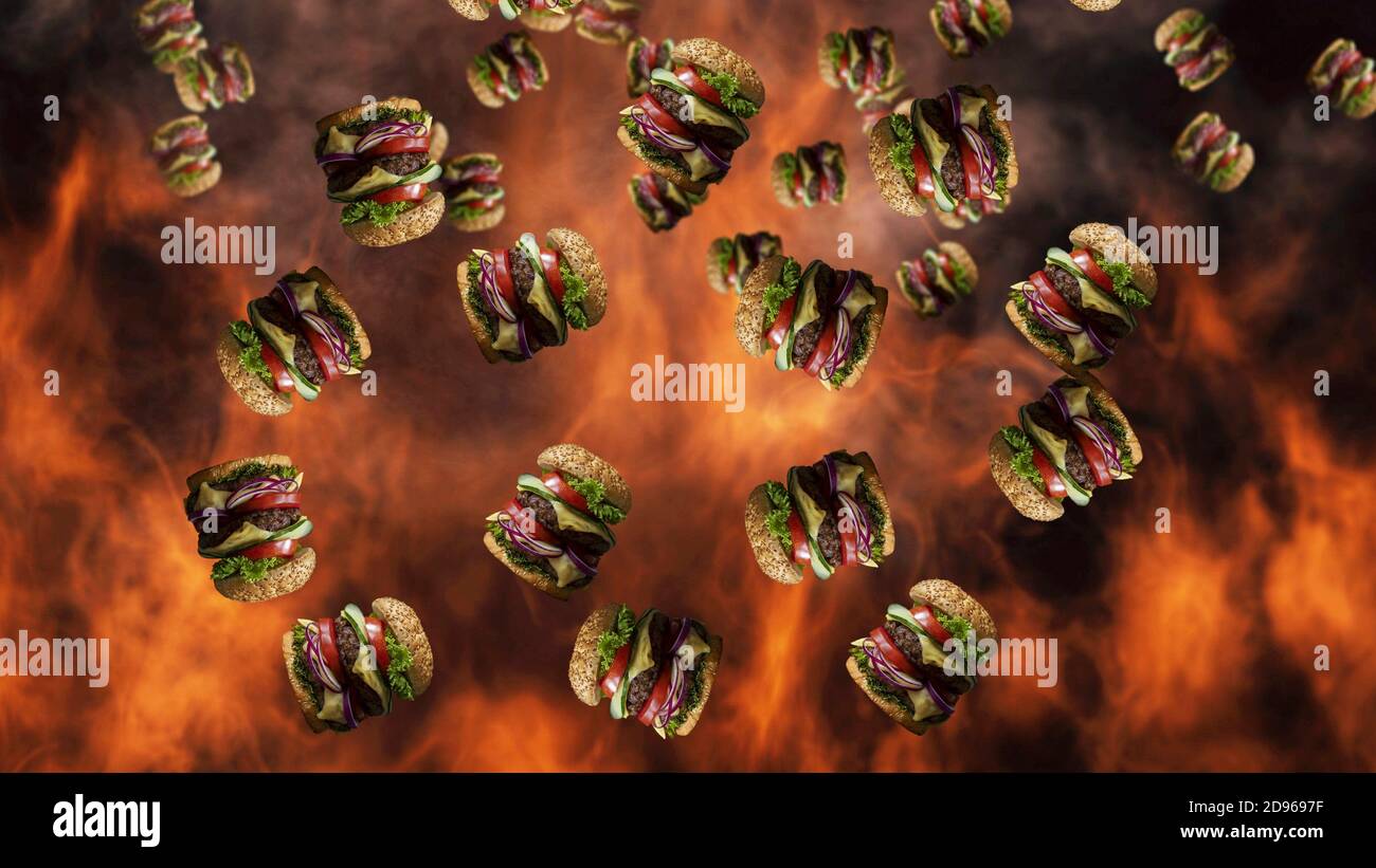 Hamburgers falling with smoke and burning fire in background. Fast food menu promo. Stock Photo
