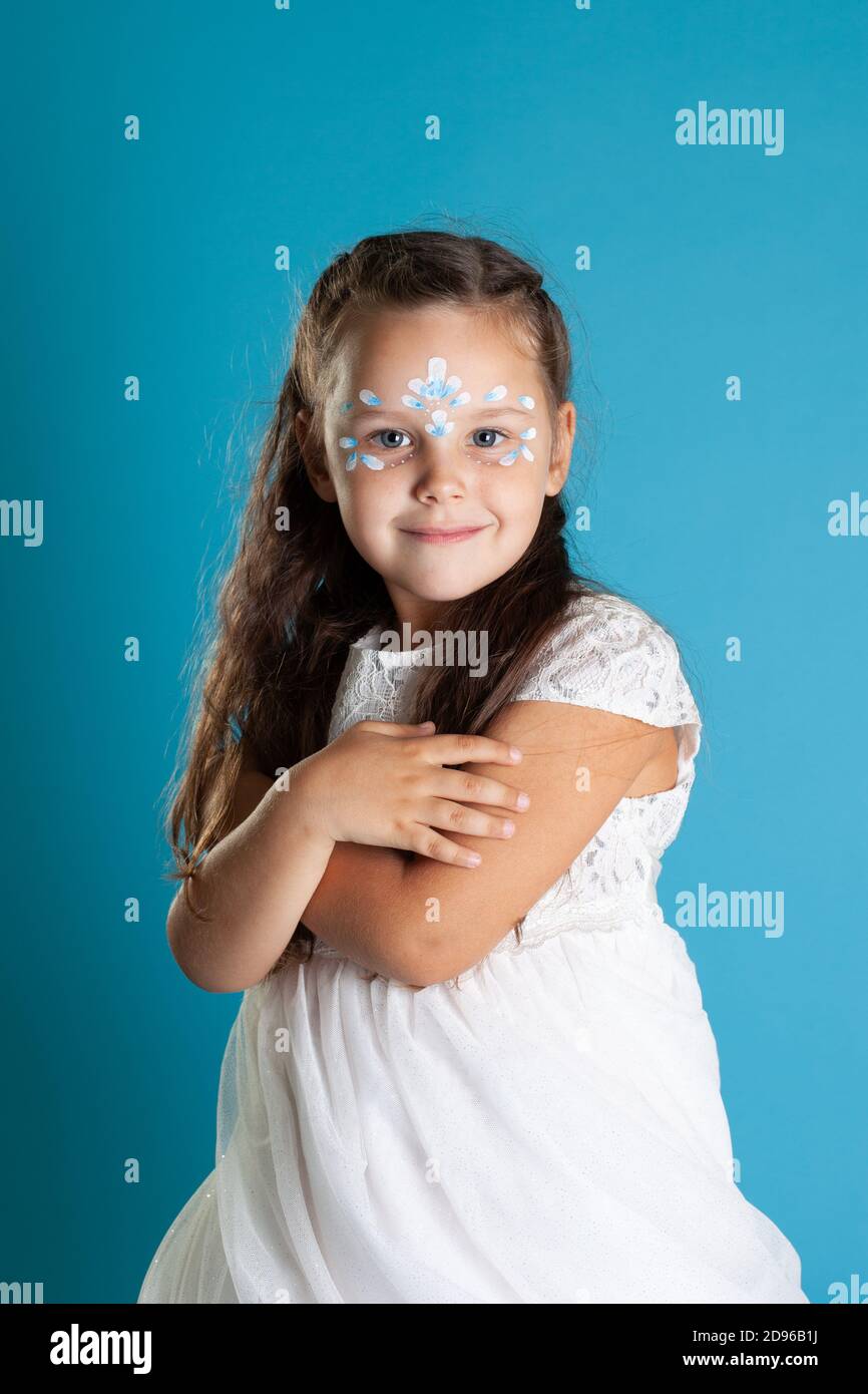 close up girl in white Princess dress and snow Queen makeup hugs herself,  isolated on blue background Stock Photo - Alamy