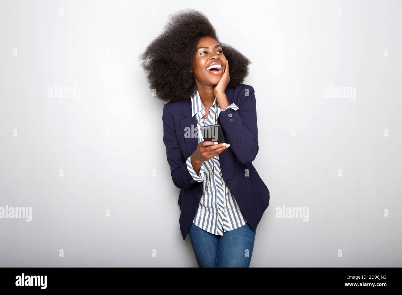 Portrait of young black woman laughing with cellphone Stock Photo - Alamy