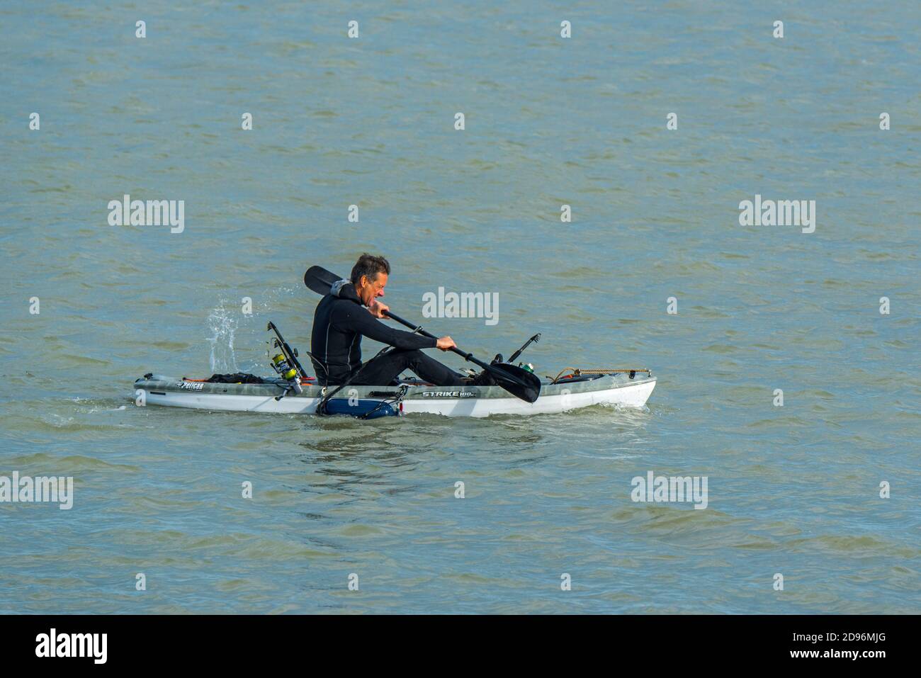 Sea angler in wetsuit paddling on the North Sea in Pelican Strike 100X Angler Kayak Stock Photo