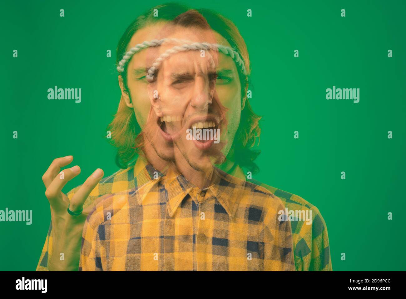 Studio shot of rebellious young man against green background Stock Photo