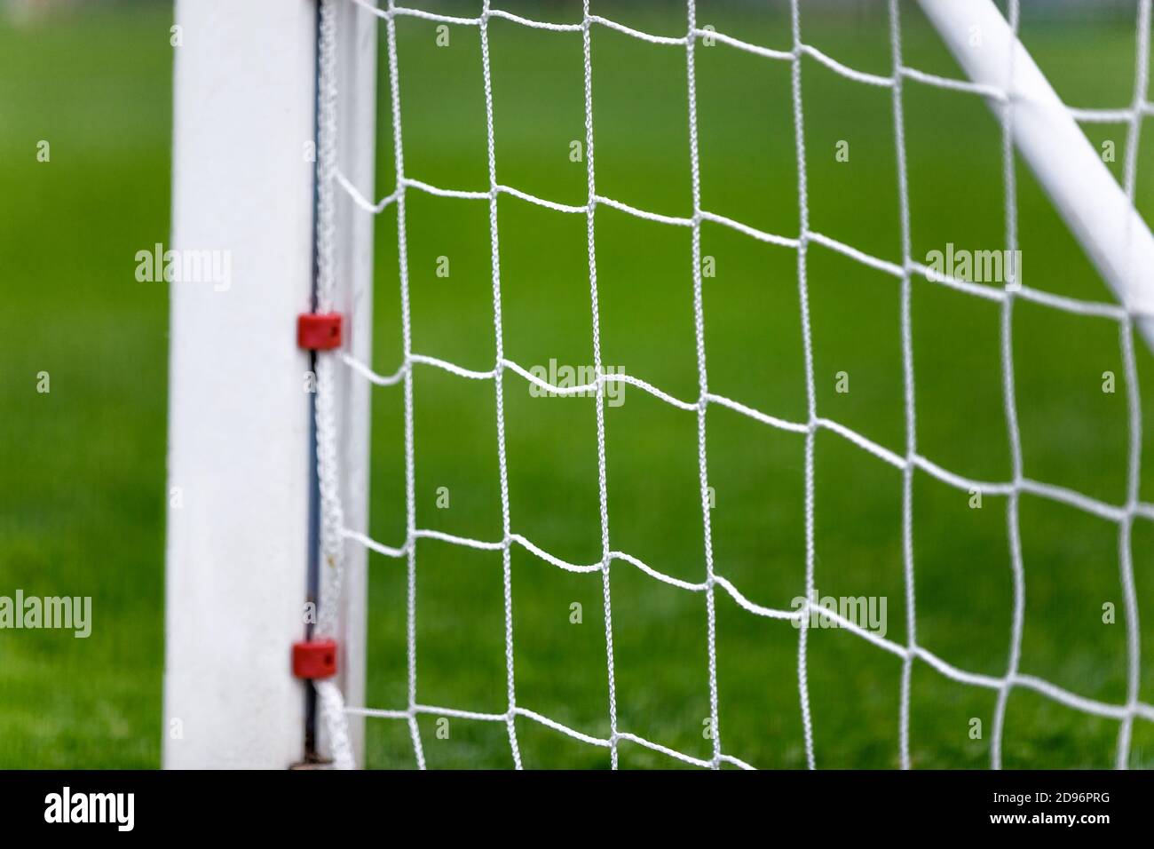 White Soccer Goal Post and Net. Grass Field in Blurred Background Stock
