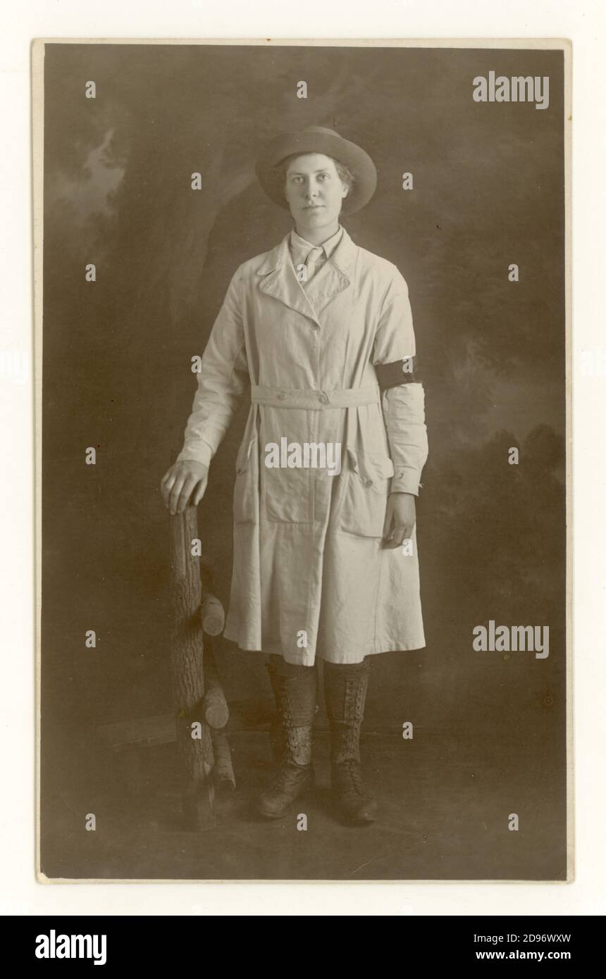 Original WW1 era studio portrait postcard of typical attractive young Land Girl wearing the standard uniform of breeches, felt hat, a knee-length overall tunic (with a button-fastening integrated belt) leather leggings and boots with national service armband denoting that she has served for 3 months  in the Women's Land Army (WLA) Liverpool, England,  U.K. circa 1917 1918 Stock Photo