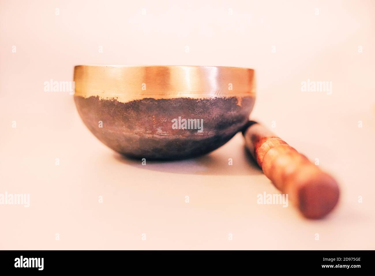 Bronze tibetan singing bowl with wooden stick on the white background Stock Photo