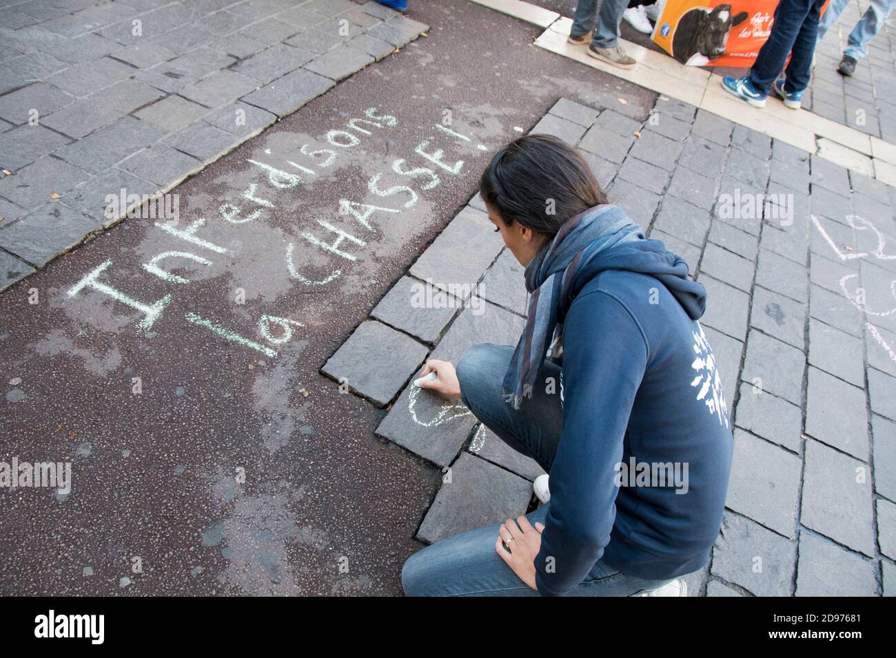 Activist writing a message with chalk on the ground during an anti-hunting demonstration, Paris, France Stock Photo
