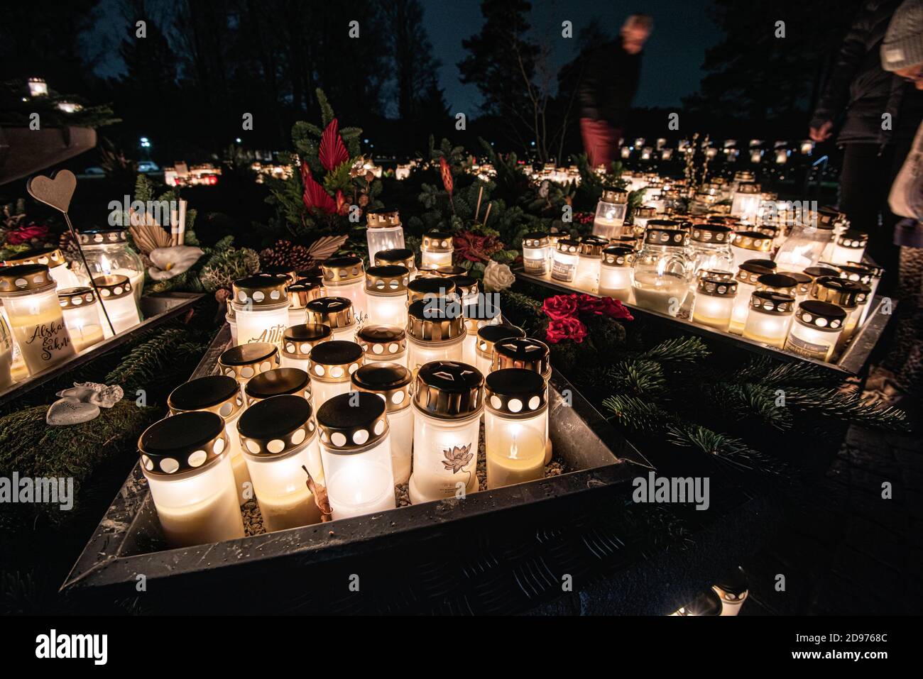 Grave candles on a cemetery on all saints eve.. Stock Photo
