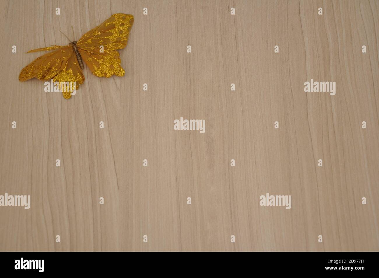 Butterfly. Golden butterfly miniature, used as decoration at Christmas time, on wooden background, copy space, Brazil, South America, zoom Stock Photo