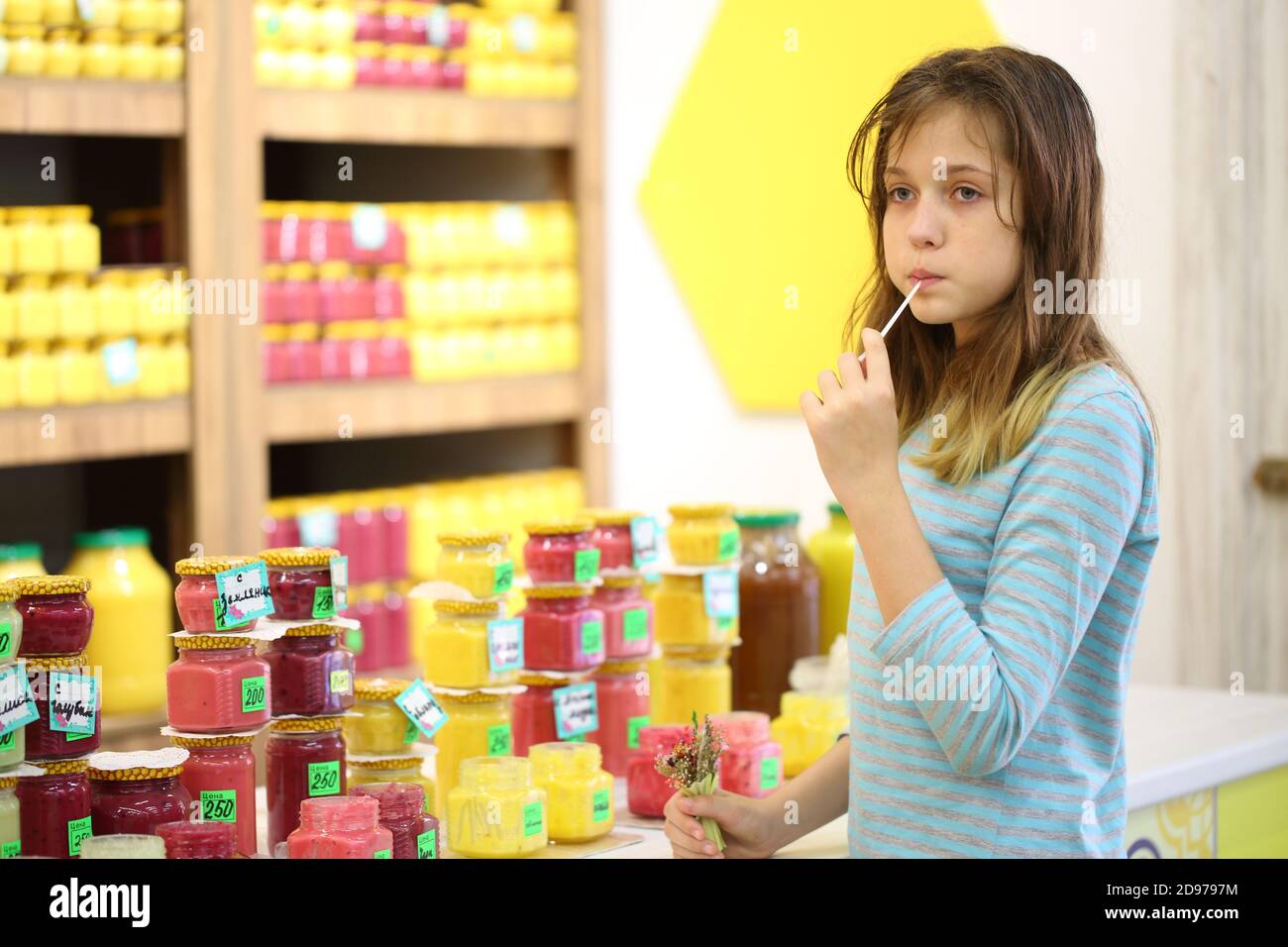 The girl in the store tastes honey Stock Photo - Alamy