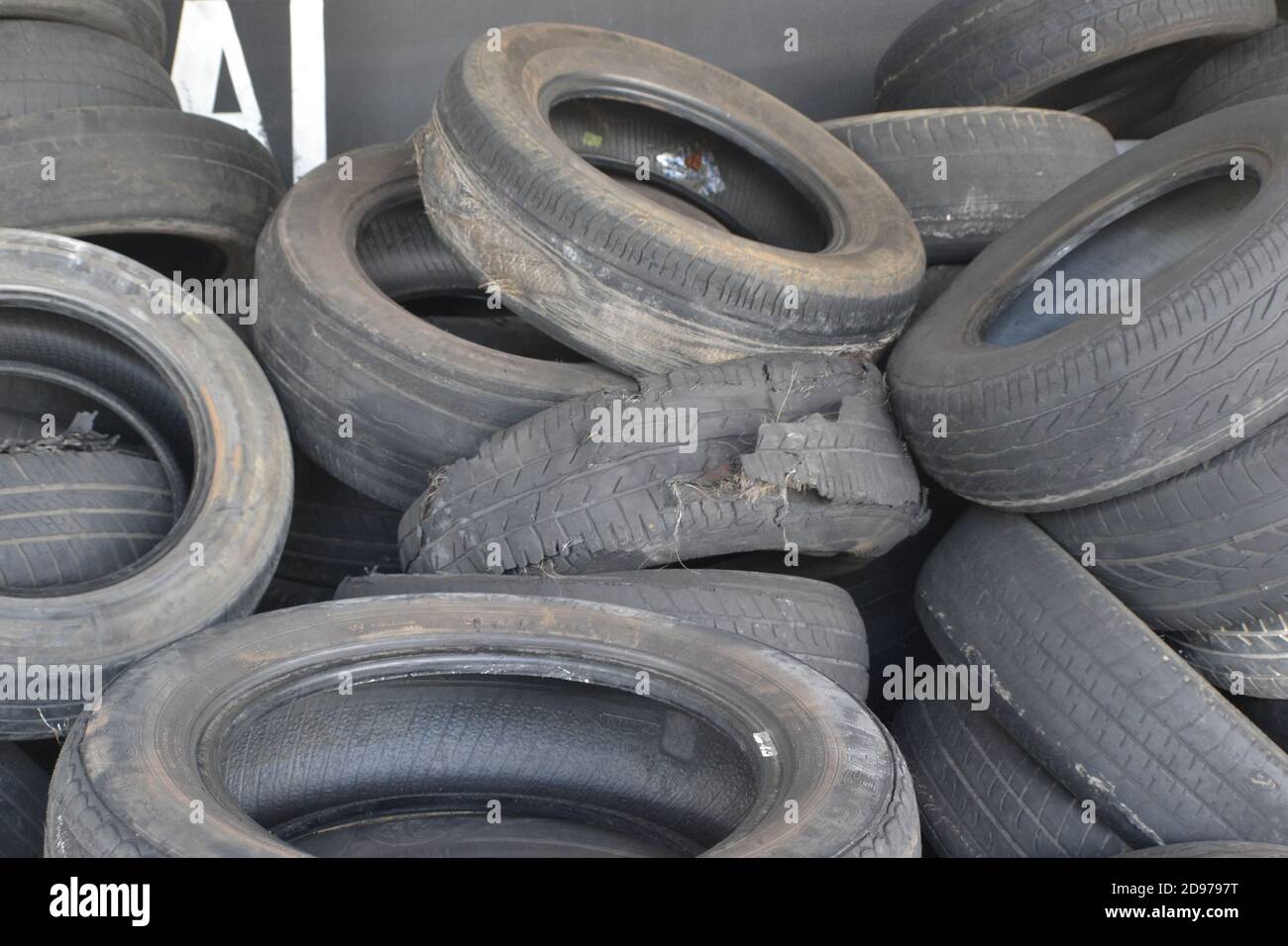 Ripped tire in a stack of tires, in front of the tire shop in the interior of Sao Paulo, Brazil Stock Photo