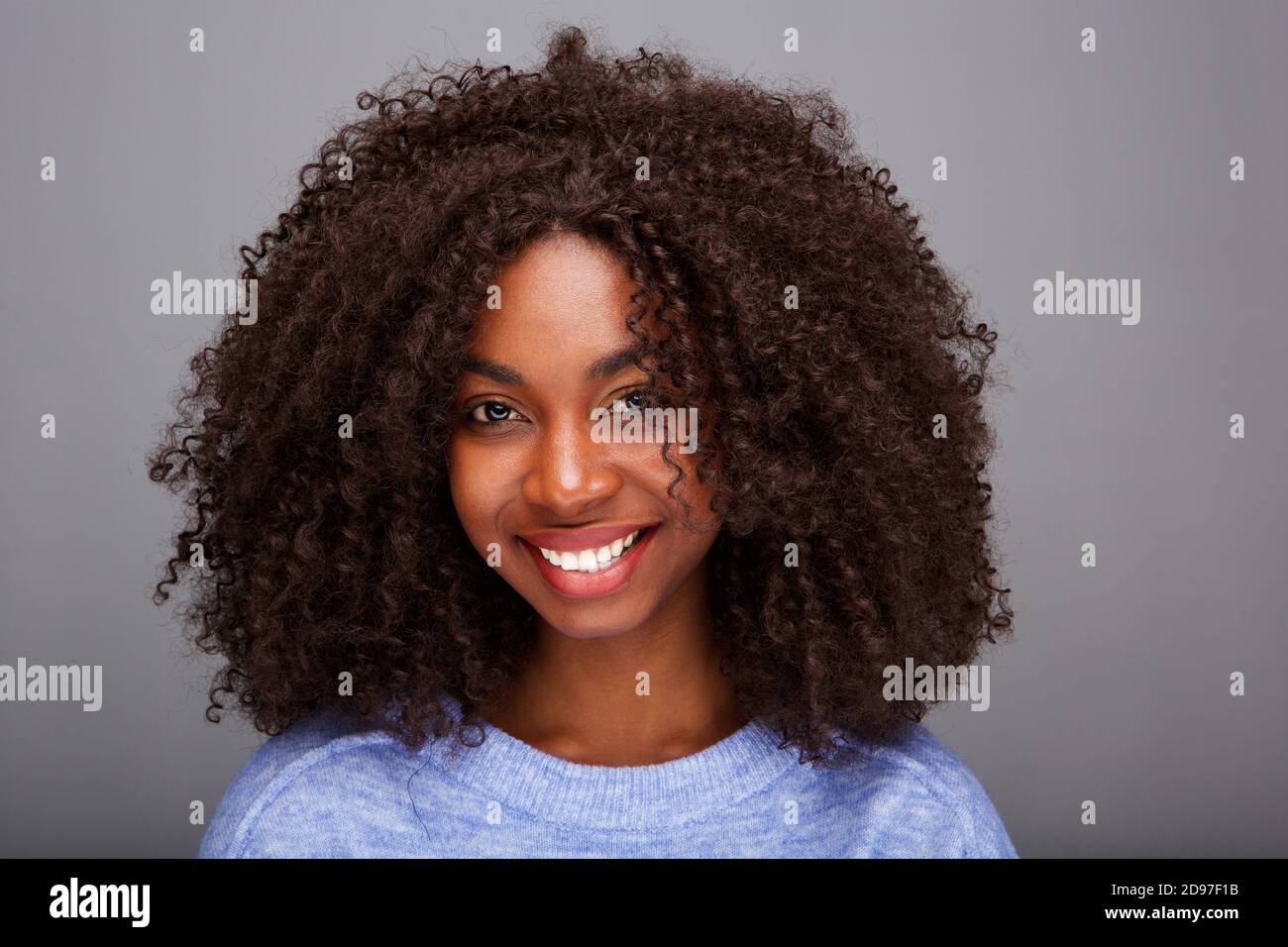 Portrait of beautiful african american woman with curly hair on gray ...
