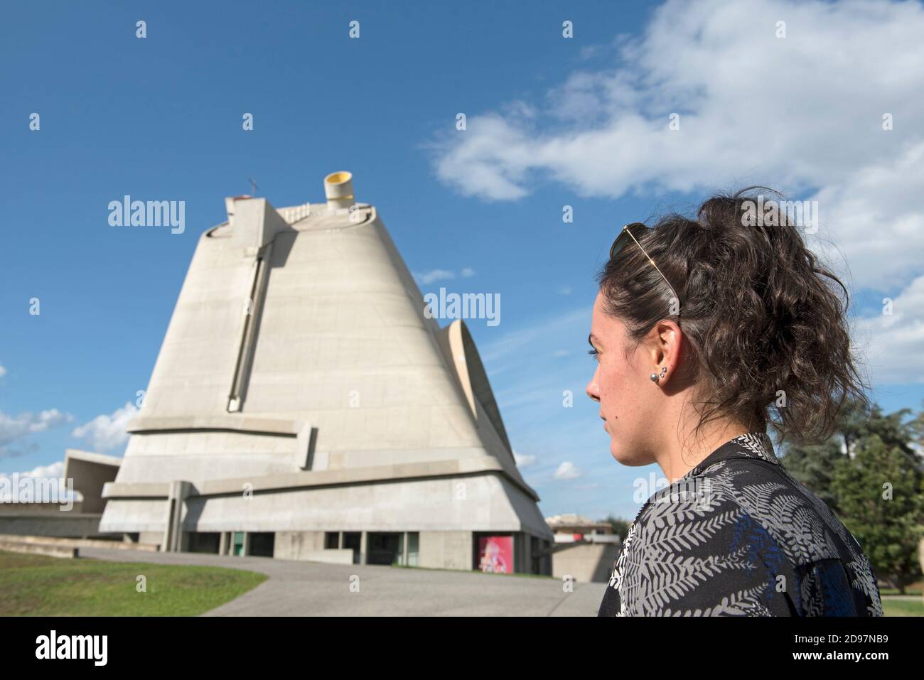 Jeune femme passant devant l'Eglise Saint-Pierre,Site Le Corbusier, Firminy, Saint-Etienne, departement de la Loire, region Auvergne-Rhone-Alpes, Stock Photo