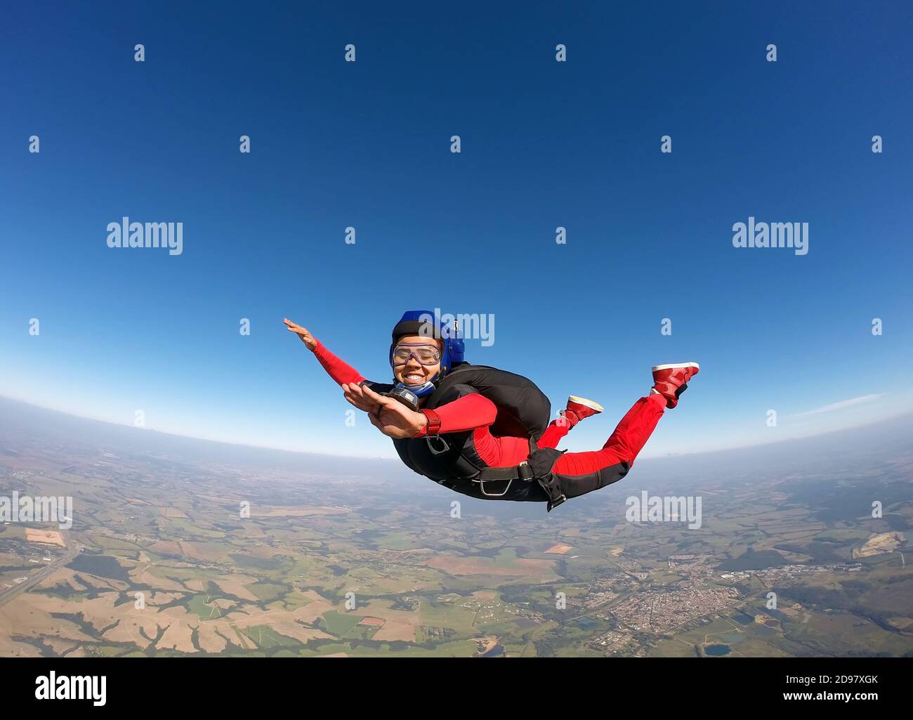 Smiling black woman jumping from parachute Stock Photo