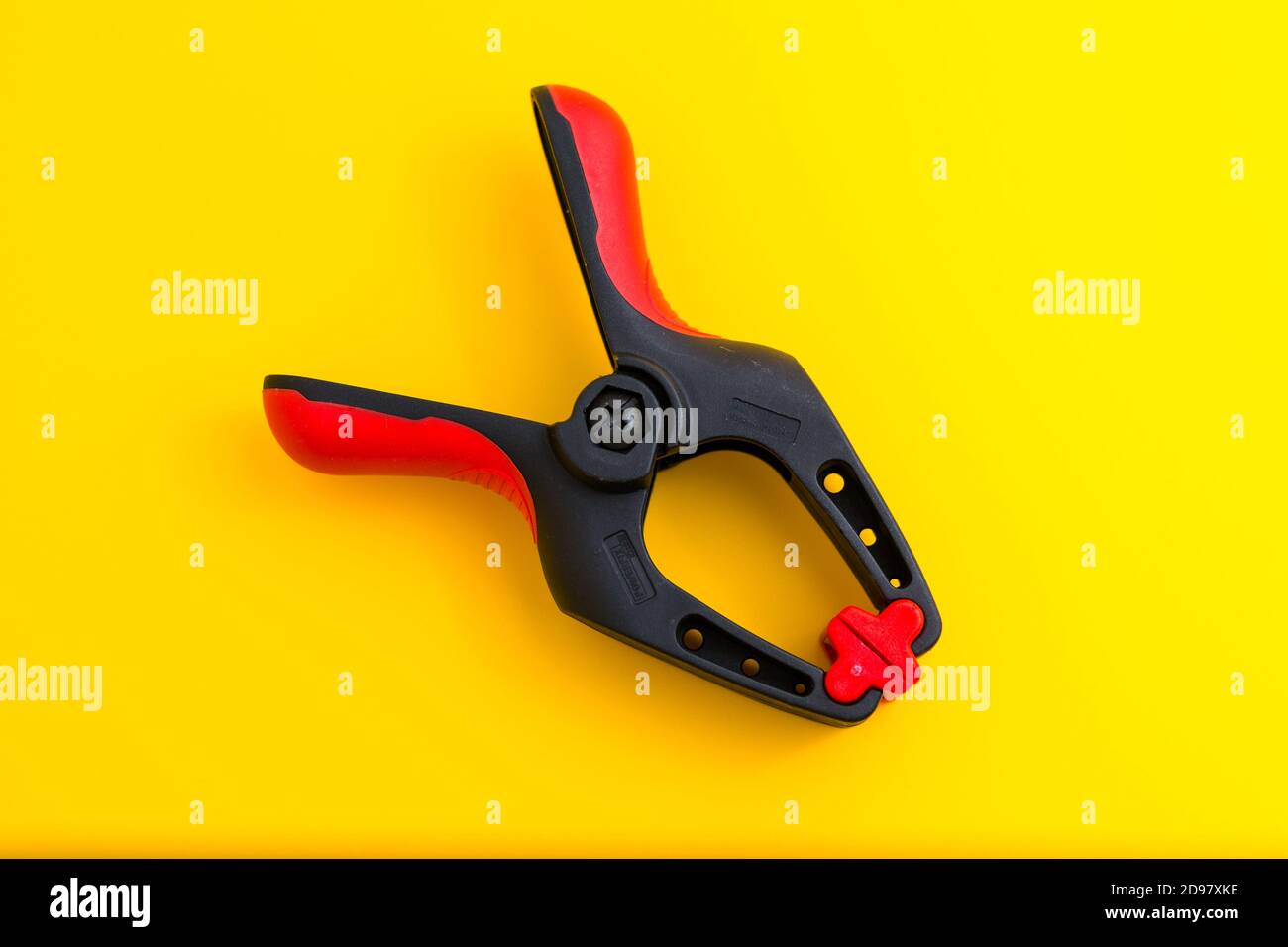 close-up photo of a clamp isolated on a yellow background Stock Photo