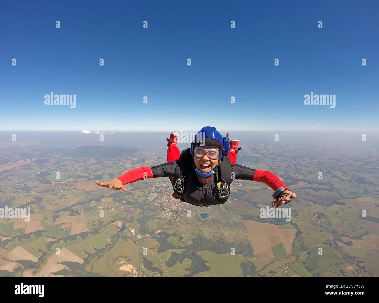 Smiling black woman jumping from parachute Stock Photo