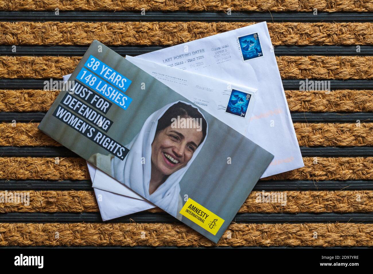 Post mail on doormat - charity appeal, Amnesty International 38 years 148 lashes just for defending women's rights Stock Photo