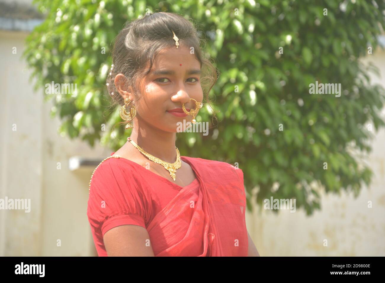 Close up of an Indian Bengali teenage girl with long dark hairs wearing  traditional yellow saree with bangles hand bag and jewelry nose ring,  earring Stock Photo - Alamy