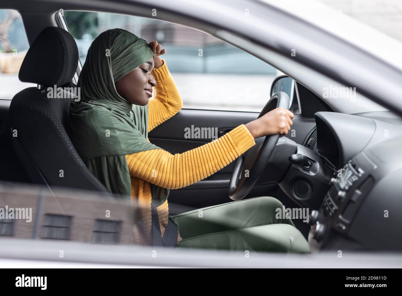 Tired African Muslim Lady Driving Car, Having Headache And Feeling Sleepy Stock Photo