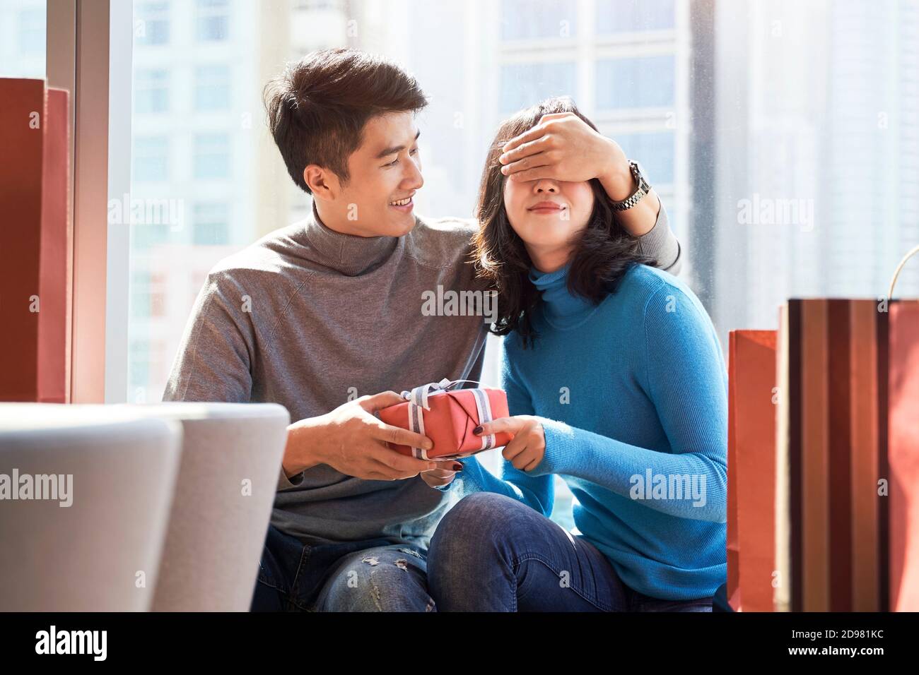 asian man giving young woman girlfriend a christmas or birthday gift Stock Photo