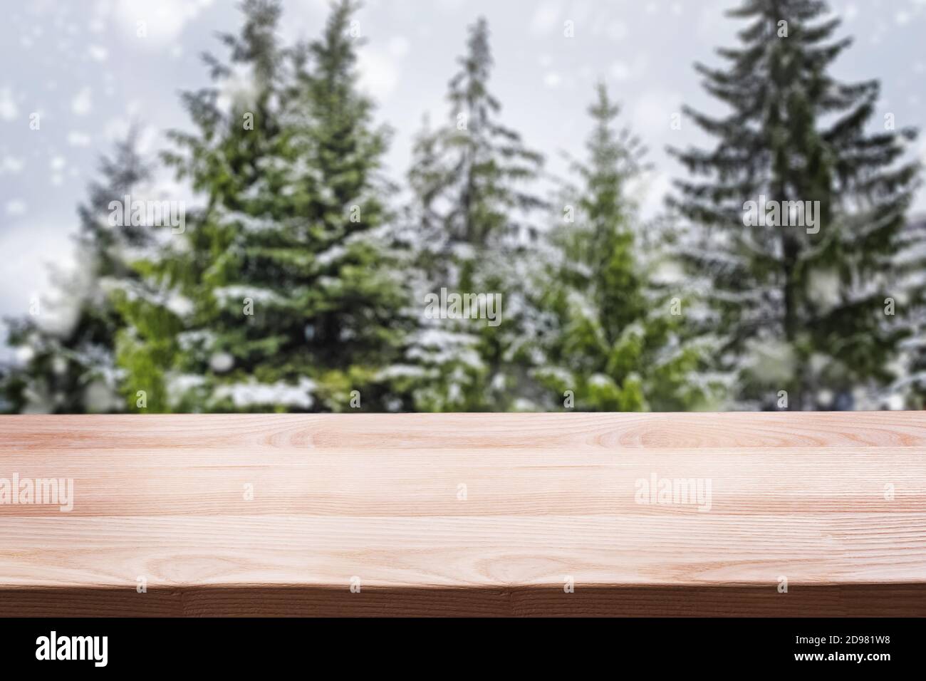 Empty woooden table top with blurred spruce trees on the background. Stock Photo