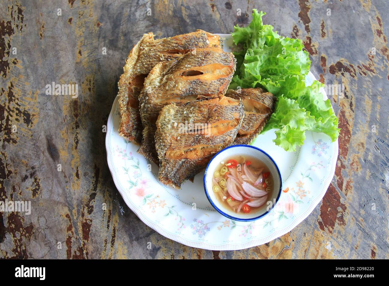 Deep-fried tilapia served with fish sauce, chili and onion mixed with lemon juice Stock Photo