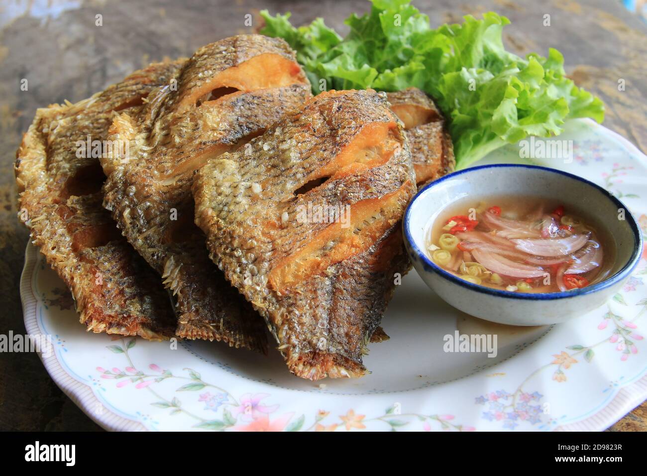 Deep-fried tilapia served with fish sauce, chili and onion mixed with lemon juice Stock Photo