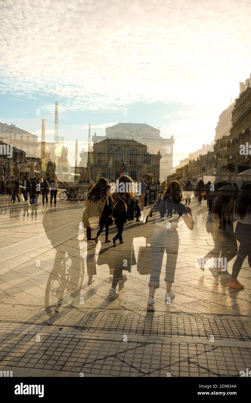 a double exposure view of crowds walking around the Place de Comedie on a sunny autumn day in the centre of Montpellier in Southern France Stock Photo