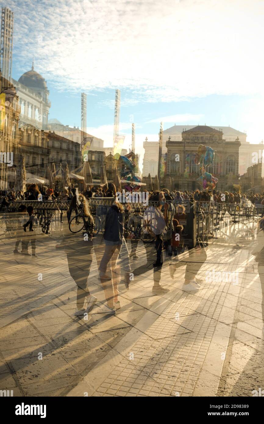 a double exposure view of crowds walking around the Place de Comedie on a sunny autumn day in the centre of Montpellier in Southern France Stock Photo