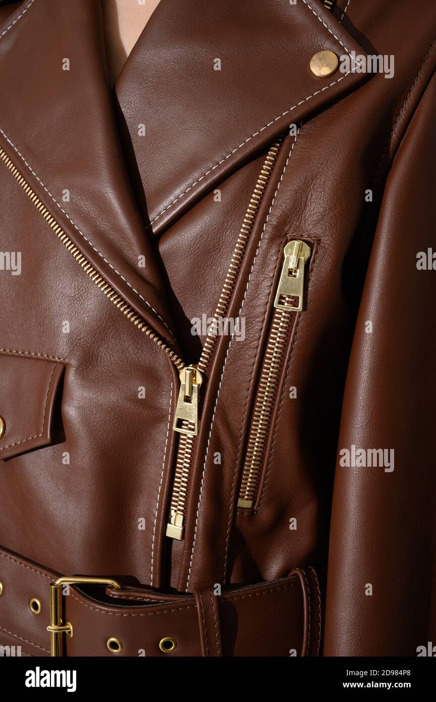 Brown leather jacket with metal zippers on it. Stitched leather. Closeup. Vertical fashion background. Stock Photo