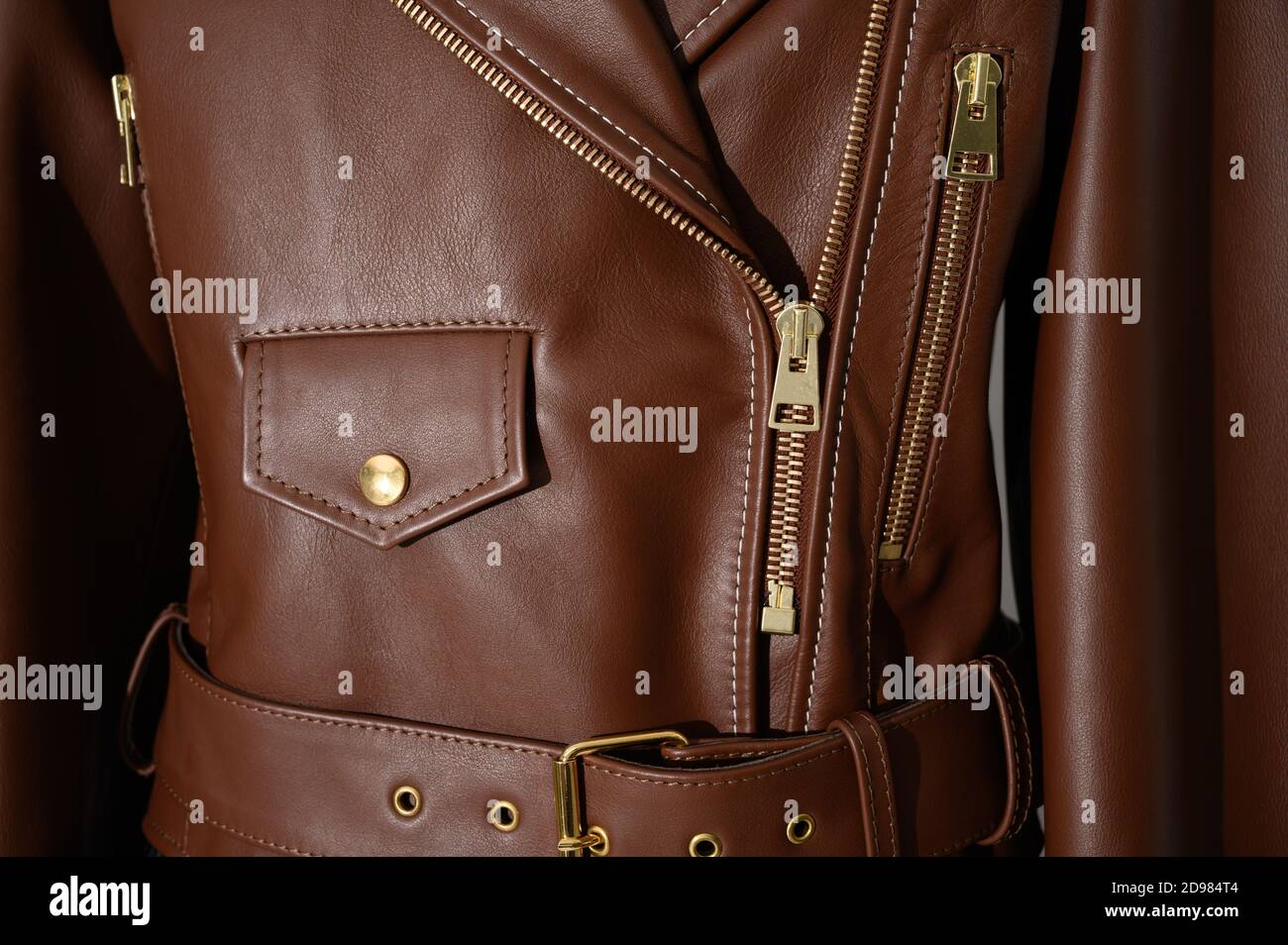 Brown leather jacket with metal zippers on it. Stitched leather. Closeup. Horizontal fashion background. Stock Photo